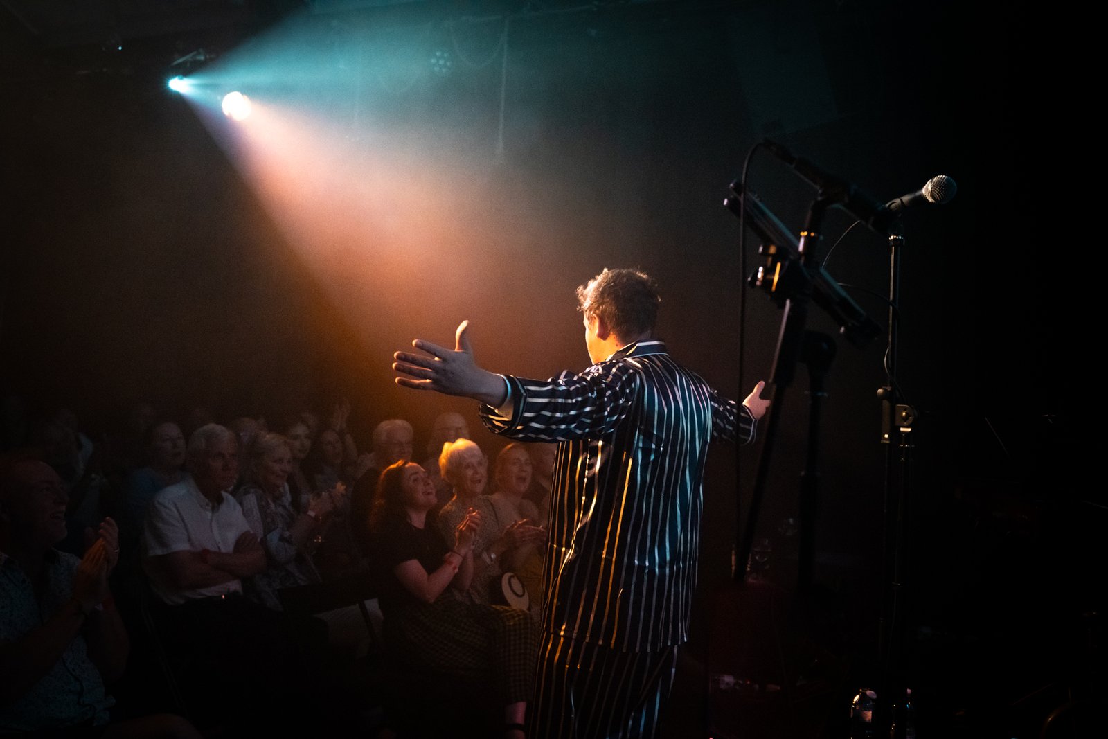 Rich Chance taking a bow in a striped suit to an applauding crowd